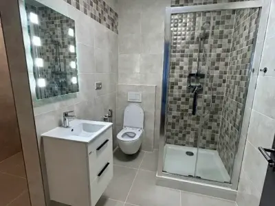 Obložení koupelny velkoformátovou dlažbou a obklady v novostavbě a instalace zařizovacích předmětů. 