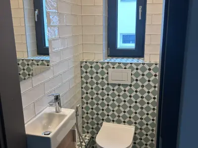 Rekonstrukce koupelny, položení dlažby, obkladů a instalace zařizovacích předmětů.